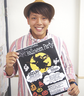 ハロウィンパーティーのポスターを手にする団長の小笹さん