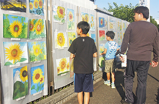 ひまわり絵画が日産フェンスに展示されている