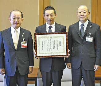 遠藤市長（左）から賞状を受け取った折本代表（中央）。右は、審査委員長の小俣副市長