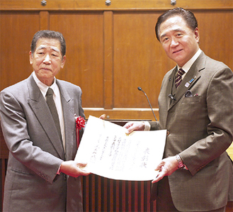 黒岩県知事から表彰状を手渡される齊田代表（左）