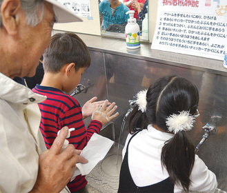 手洗いマイスター指導のもと手を洗う児童