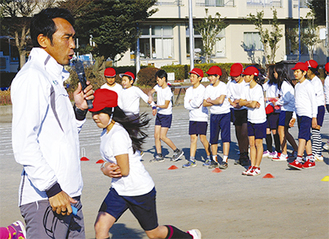 高野さんの指導で校庭を走る児童たち