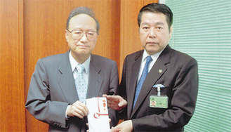田中会長（左）と義援金を受け取る小林市長