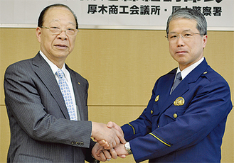 握手を交わす石川会頭（左）と鈴木署長