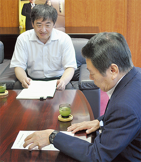 前田委員長（左）の説明を受ける小林市長