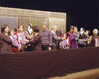舞台の上で人形芝居を体験する参加者