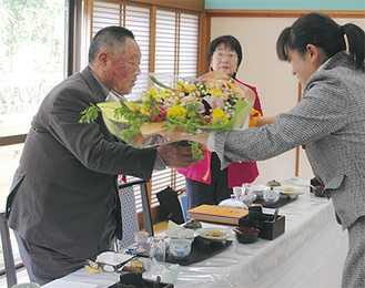 会員から花束を受け取る結社創始者の山本会長