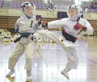 小学３・４年男子の決勝で中段蹴りをする選手