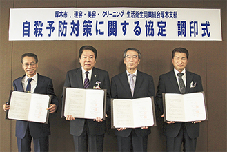 協定書をもつ小林市長（左から2番目）と支部長ら