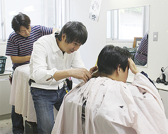 入所者の散髪をする理容師たち
