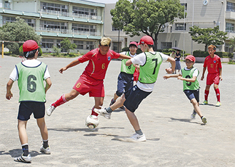 赤いユニフォームの韓国チームに挑む児童