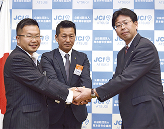 握手をする（左から）小澤理事長、長島部長、北村会長