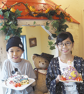 大賞を受賞した藤川さん(右)と角田さん。デザイン画のケーキを授与され笑顔いっぱい