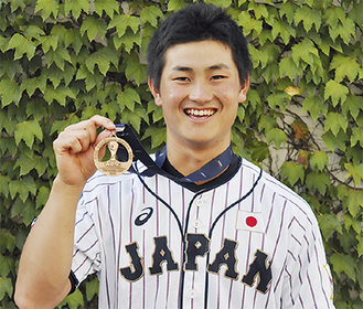 日本代表のユニフォームを着てメダルを見せる井上さん