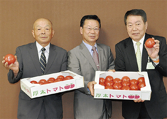 トマトを贈呈する木原部会長（中央）と和田副部会長（左）