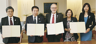 調印した覚書を手にする（左から）曽田教育長、小林市長、スティーブン・ペイトンＮＺ大使館特命全権大使、アデル・ブライアントＥＮＺ中国・北アジア局長、北岡美佐子ＥＮＺ駐日代表