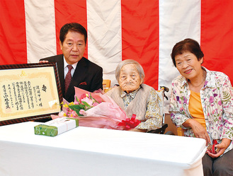 花束を受け取るヤマさん（中央）と祝いに駆け付けた悦枝さん（右）＝写真提供・厚木市
