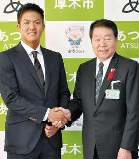 小林市長と握手を交わす田中俊太選手（左）