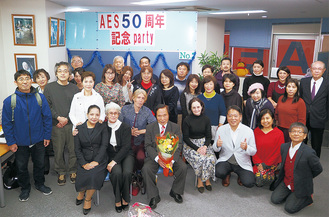 50周年を祝い、講師陣や生徒らが参加したパーティ。中央で花束を持つのが松本一也学院長