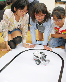 ロボットの動きを夢中で追う児童たち。自由な発想で入力できる「遊び感覚」の授業は毎回好評だ