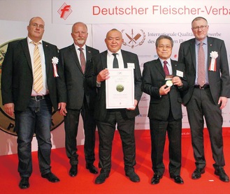 授賞式での記念撮影。ソーセージ製造を手掛けた松田さん（中央）と、岩澤吉美村長（右から２人目）、審査委員