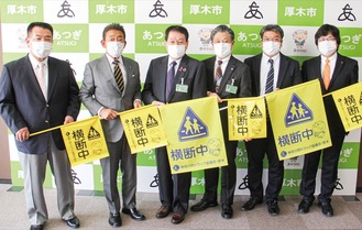 横断旗を手渡した左から平島委員長、浅生会長、小林市長、曽田教育長、伊澤副会長、神子雅人市議