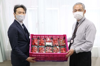愛川北部病院職員にイチゴを手渡す澤村総務部長（左）