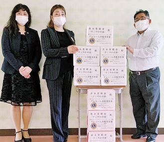 消毒液を届けた同クラブの落合さん（左）と川上さん（中央）、受け取る里親会の西川会長