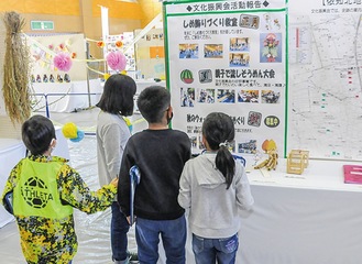 公民館活動展の展示をじっくりと見る児童