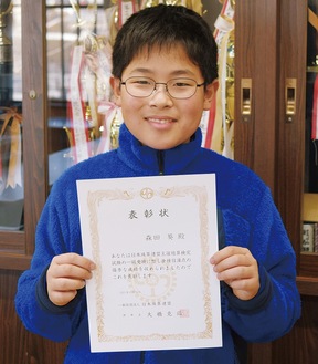 表彰状を手に笑顔を見せる森田さん