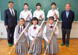 竹刀を寄贈した小山会長（左）、中村隆一さん（右）と生徒