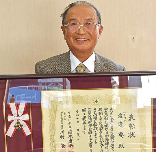 緑十字金章と表彰状を手にする渡辺さん