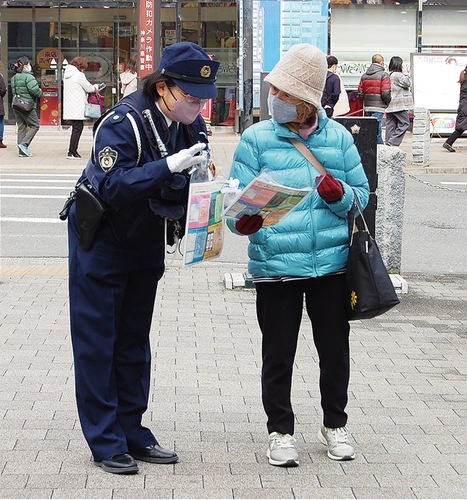 通行人に啓発物品を手渡し注意喚起をする署員