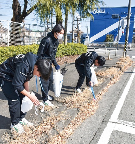 歩道や車道のごみを拾う参加者