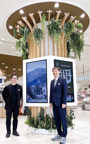 シンボルツリーの前に立つ青木店長（右）と金子さん（左）