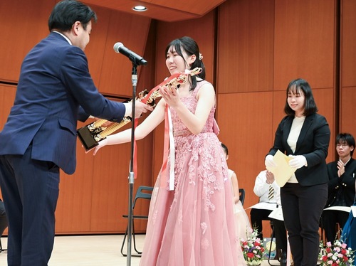 山口貴裕市長からトロフィーを受け取る吉田さん