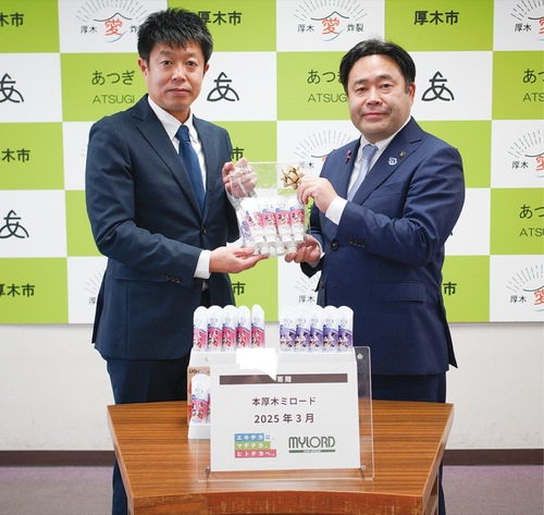 歯磨き粉を手渡す永山支配人（左）