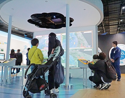 デジタルパネルでドローンを操作する来場者