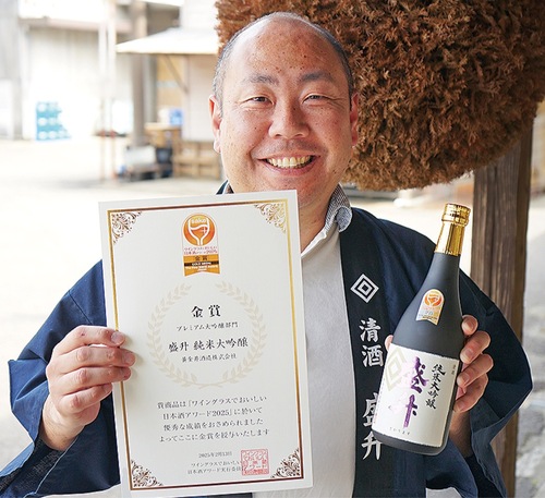 賞状と純米大吟醸を手にする黄金井専務