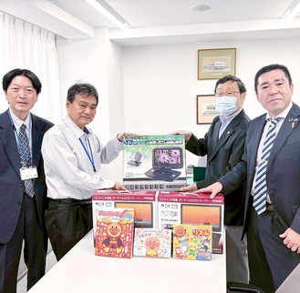 高木所長（中央左）に寄贈品を手渡す柴田会長