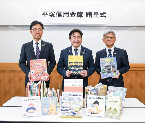 寄贈本を手にする山口市長（中央）と平塚信用金庫の井萱誠常務理事（右）、小池隆史厚木南エリア支店長（左）