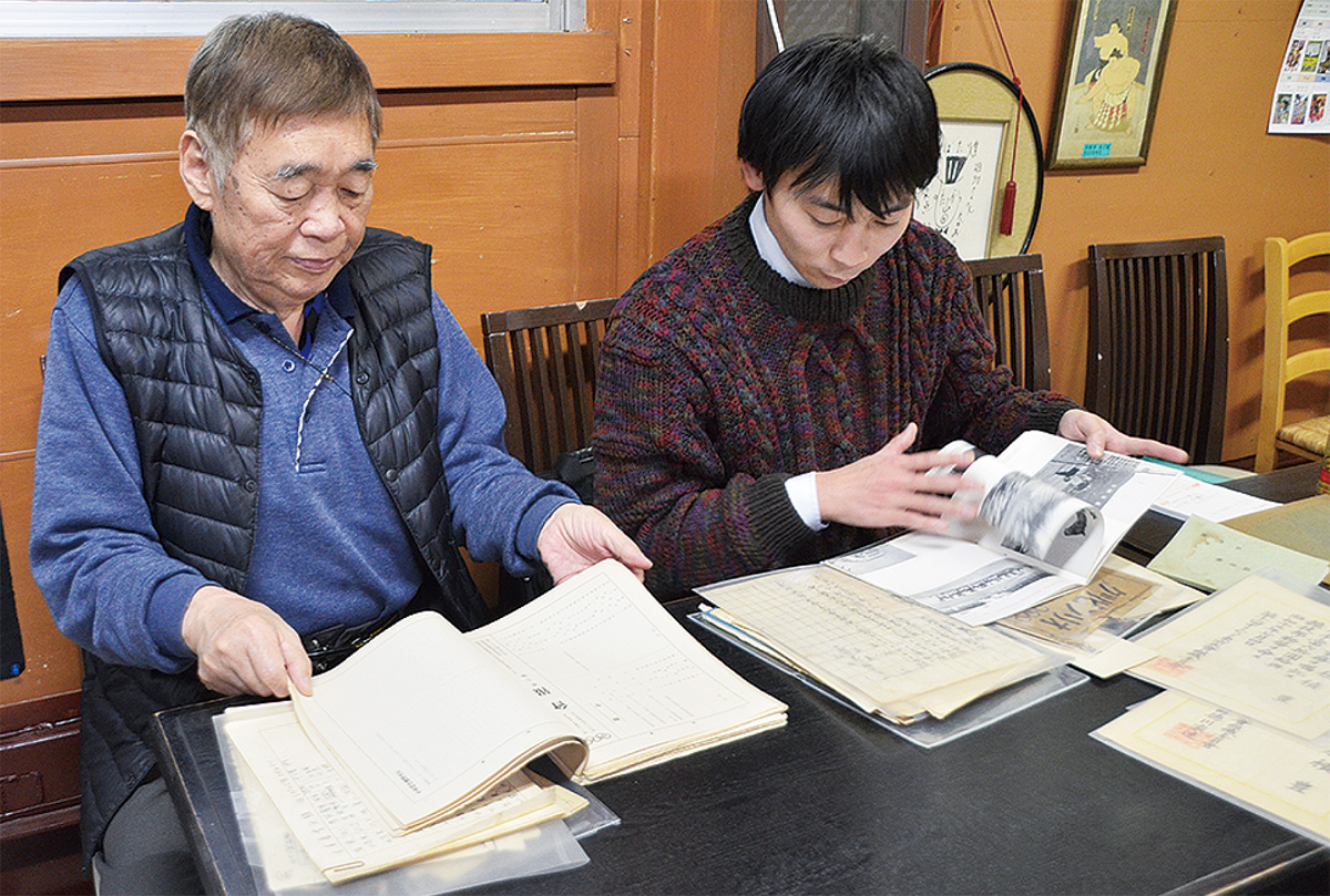 資料に目を通す遊佐省三さん（左）と貴幸さん