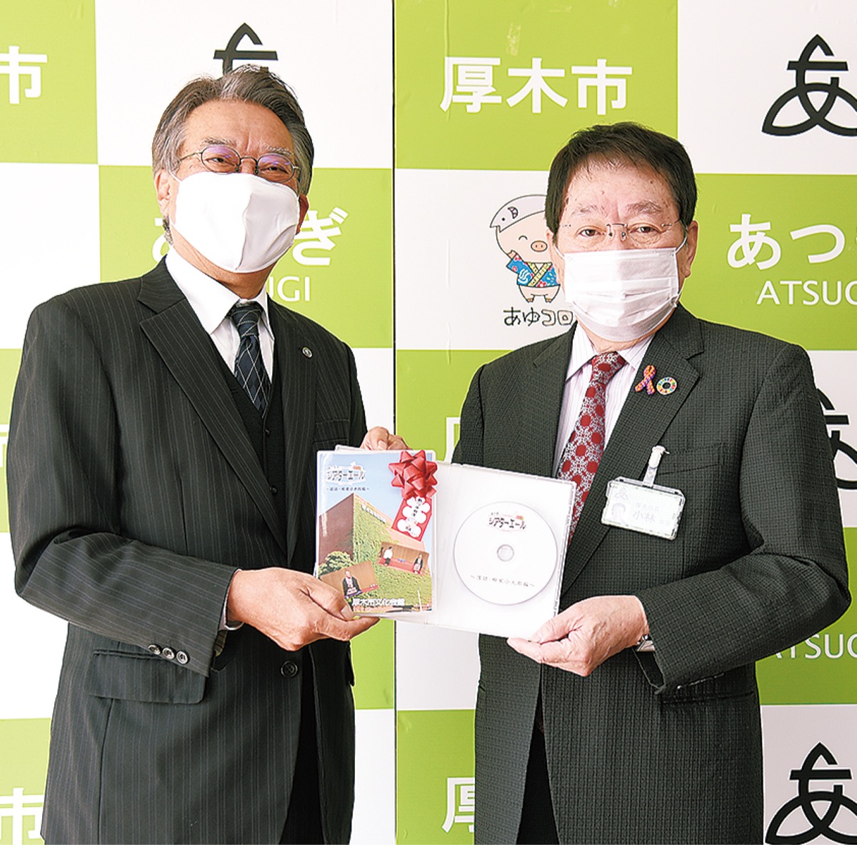 ＤＶＤを手渡す平井理事長（左）と小林市長