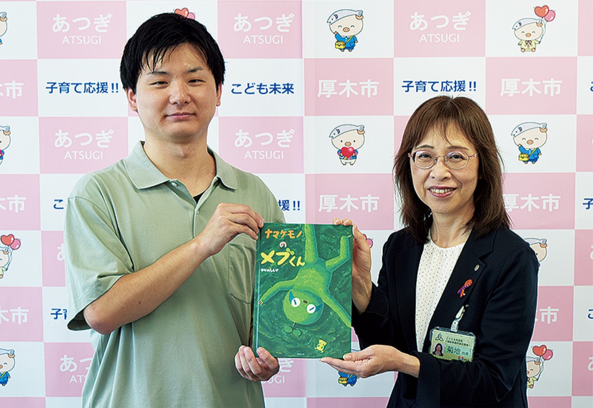 絵本を寄贈したかやのさん（左）