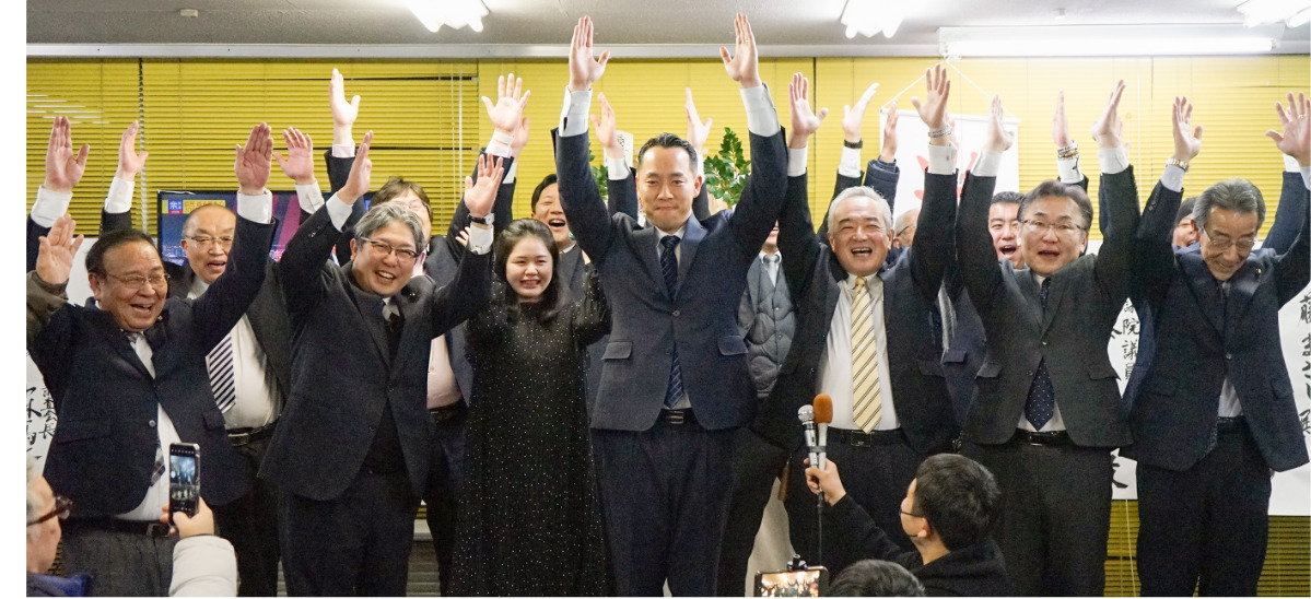 万歳三唱で当選を喜ぶ佐藤氏（写真中央）＝２月９日厚木市内の選挙事務で