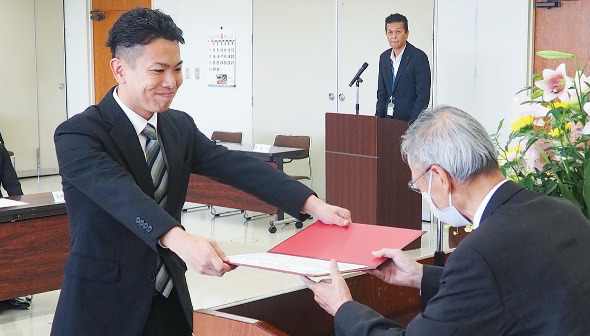 笑顔で当選証書を受け取る茅氏