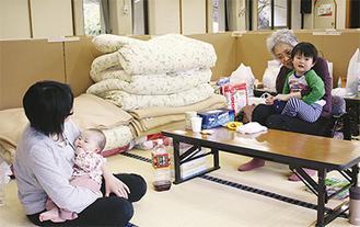 避難所で子どもの世話をする松浦さん（左）と伊勢亀さん