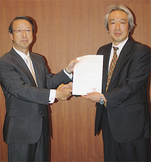 握手を交わす飯田副会長（左）と小柴学部長