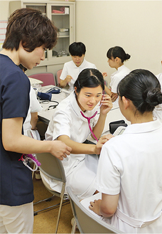 現役看護師から聴診器の使い方を習う高校生たち