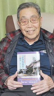 自身の本を手に笑顔の田中さん